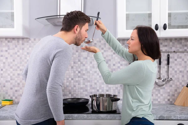 Jolie Femme Faisant Son Mari Pour Goûter Nourriture Dans Cuisine — Photo