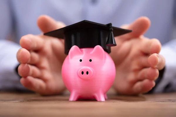 Close Van Een Man Hand Beschermen Piggy Bank Met Graduation — Stockfoto