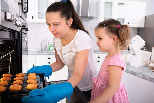 Giovane Madre Tenendo Vassoio Cupcake Con Sua Figlia Cucina — Foto Stock