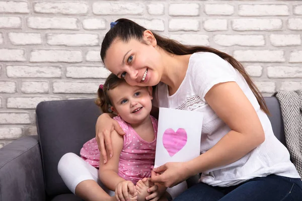 Smiling Mother Hugging Her Little Daughter Holding Love Card Hand — Stock Photo, Image