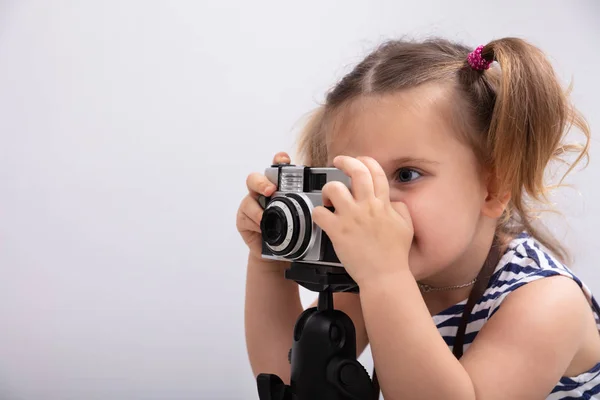 Fotoğraf Makinesiyle Fotoğraf Çekilirken Beyaz Arkaplan Karşı Duran Küçük Kız — Stok fotoğraf