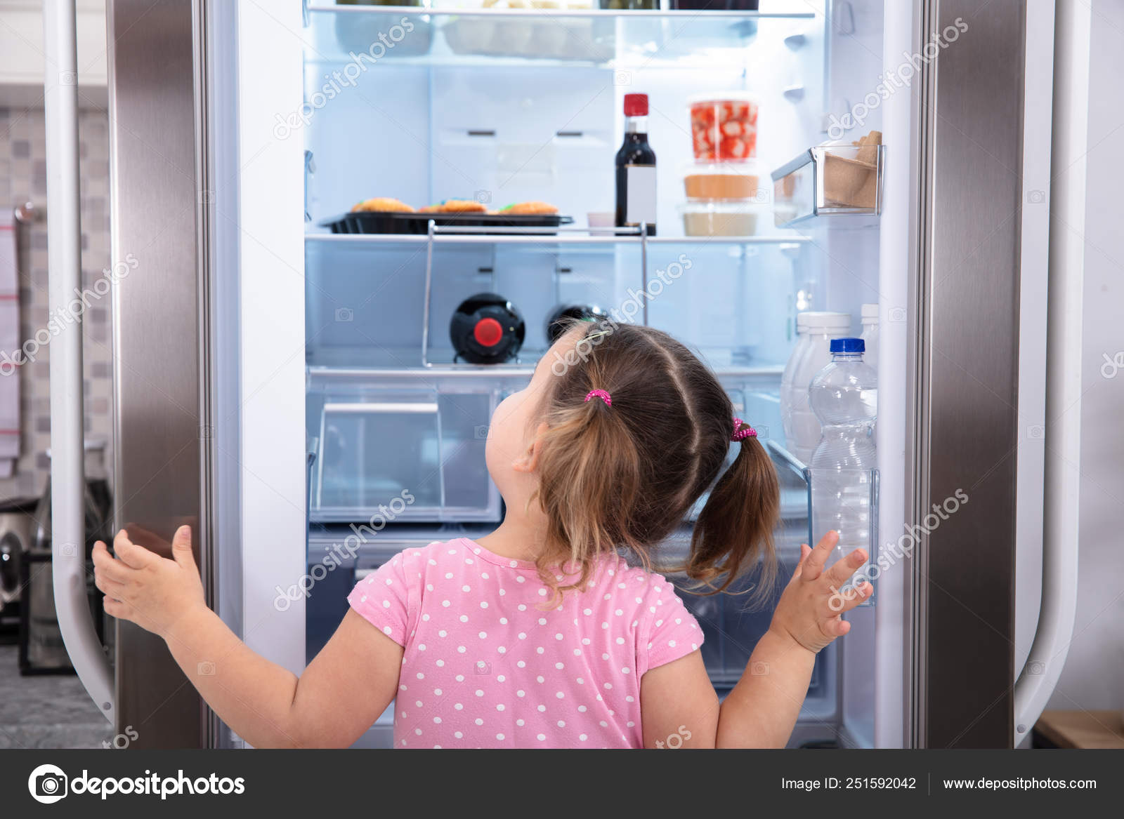 Rear View Girl Standing Kitchen Opening Fridge Door Looking