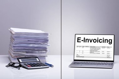 Stacked Of E-invoice Paper And Calculator Is Replace With New Technology Against White Background clipart