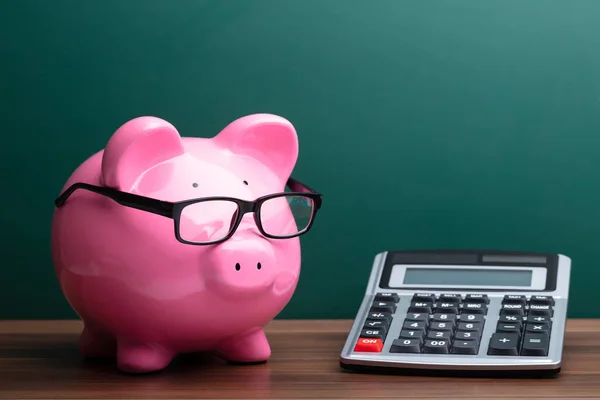 Calculadora Piggybank Rosa Con Gafas Delante Junta Verde — Foto de Stock