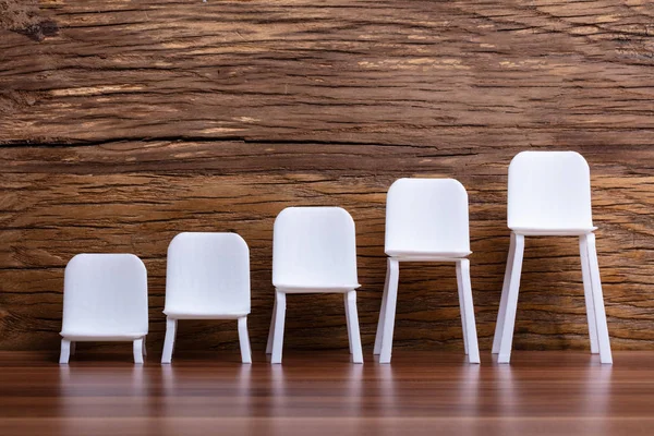 Empty Miniature Increasing Scale White Chair Wooden Background — Stock Photo, Image