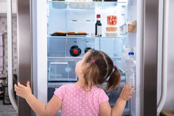 Visão Traseira Menina Cozinha Abertura Porta Frigorífico Olhando Para Dentro — Fotografia de Stock