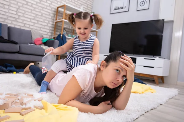 Menina Travesso Feliz Brincando Com Sua Mãe Cansada Deitado Tapete — Fotografia de Stock