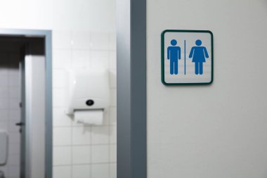 Beyaz Duvarda Erkek ve Kadın Tuvaleti Tabelası Yazılı Umumi Tuvalet