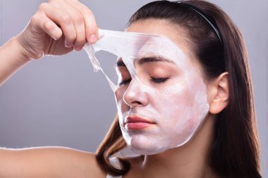 Yüzünü maske Peeling kaldırma güzel bir genç kadının portresi