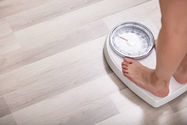 自宅で体重計に足の女性の低セクション — ストック写真