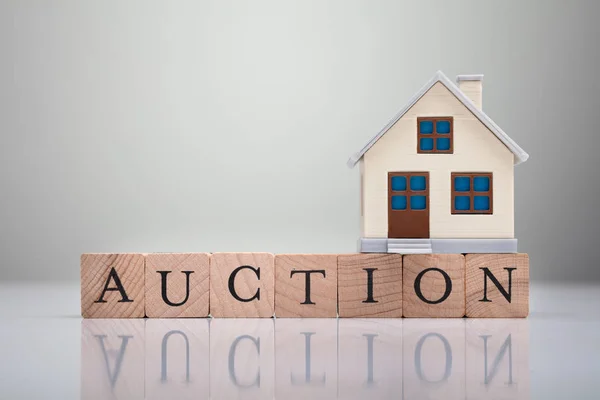 Nahaufnahme Des Hausmodells Über Auktionstext Holzblöcke Vor Grauem Hintergrund — Stockfoto