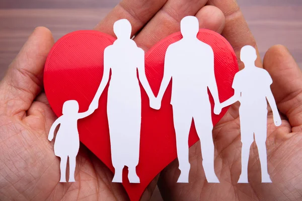 Close Mão Pessoa Segurando Família Cortada Coração Vermelho Sobre Mesa — Fotografia de Stock