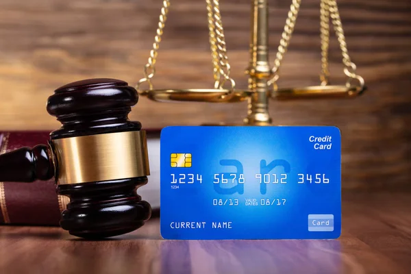 Blaue Kreditkarte Und Hammer Vor Goldener Messwaage Auf Holztisch — Stockfoto
