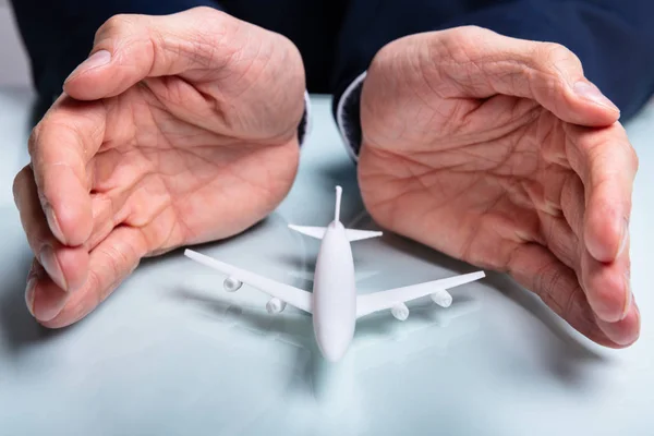 Primer Plano Mano Del Hombre Protegiendo Avión Escritorio Blanco — Foto de Stock