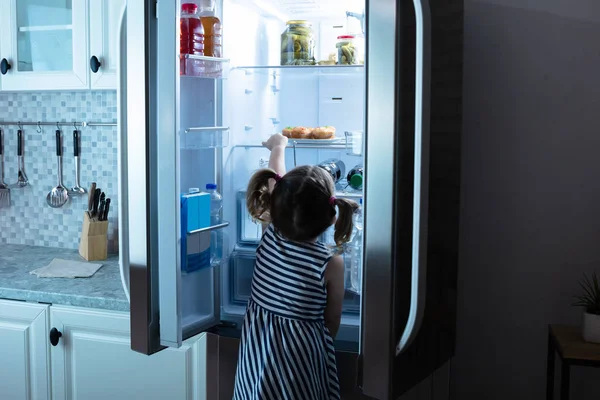 Вид Сзади Девушка Пытается Взять Кексы Холодильника Кухне — стоковое фото