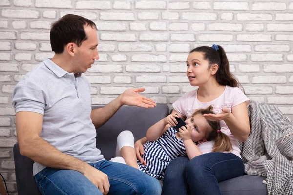 Paar Streitet Hause Während Ihre Tochter Handy Auf Sofa Benutzt — Stockfoto