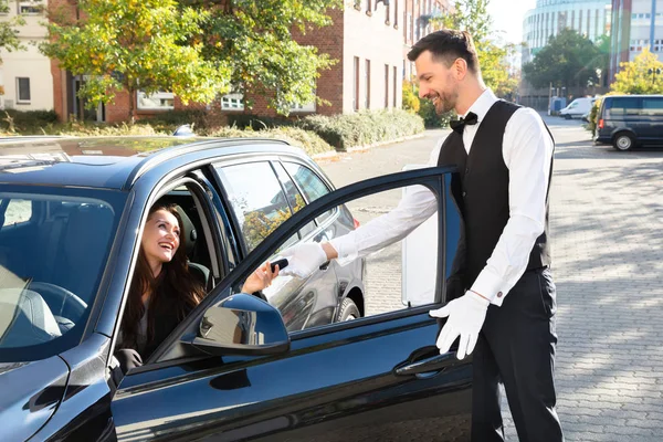 Sorrindo Jovem Mulher Sentada Carro Dando Chave Carro Para Valet — Fotografia de Stock