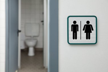 Beyaz Duvarda Erkek ve Kadın Tuvaleti Tabelası Yazılı Umumi Tuvalet