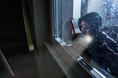 Levyeli Hırsız ve el feneri Bir evin penceresine bakıyor