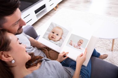 Kanepede Oturan Bir Çiftin Yüksek Açılı Görünümü Fotoğraf Albümüne Bakıyor