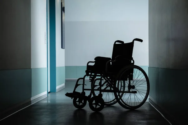 医院走廊中停放的空轮椅的轮廓 — 图库照片