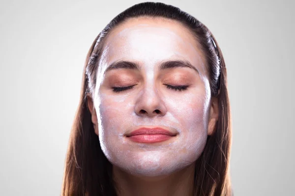 Mujer Joven Sonriente Con Máscara Facial Contra Fondo Gris —  Fotos de Stock