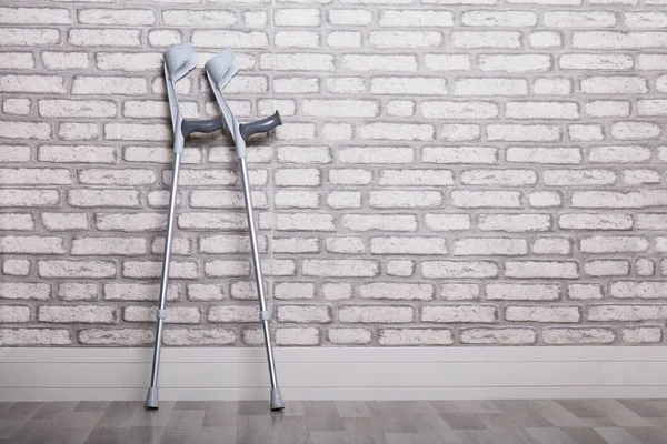 Pair Crutches Leaning Brick Wall — Stock Photo, Image