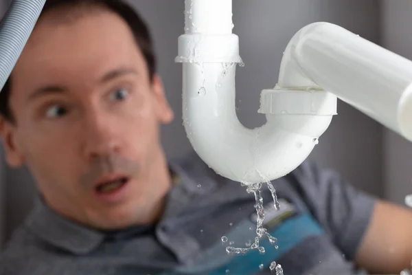 Joven Sorprendido Mirando Fugas Tubería Fregadero Cocina — Foto de Stock