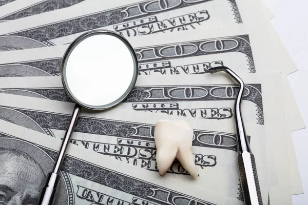 牙科工具和牙齿在美元纸币上的提升视图 — 图库照片