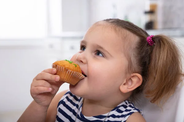 Boldog Ártatlan Lány Taking Harapás Delicious Cupcake Konyhában — Stock Fotó