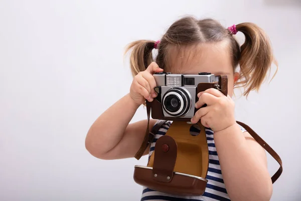 Mała Dziewczynka Stojąca Białym Tle Podczas Fotografowania Przy Użyciu Aparatu — Zdjęcie stockowe
