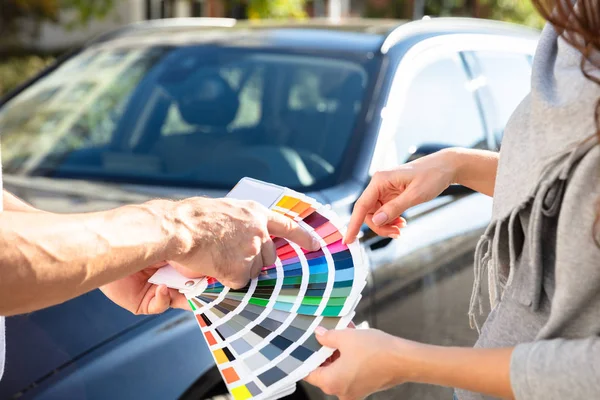 Close Man Wyświetla Próbki Kolorów Kobiety Stojącej Przed Samochodem — Zdjęcie stockowe