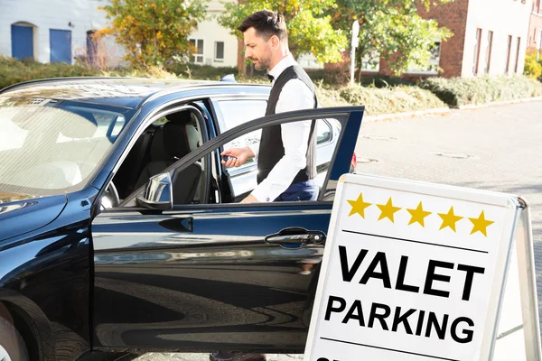 Voiturier Masculin Heureux Ouvrant Porte Voiture Près Valet Parking Signe — Photo