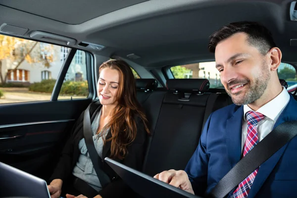 Zwei Glückliche Geschäftsleute Die Elektronische Geräte Während Ihrer Autofahrt Benutzen — Stockfoto