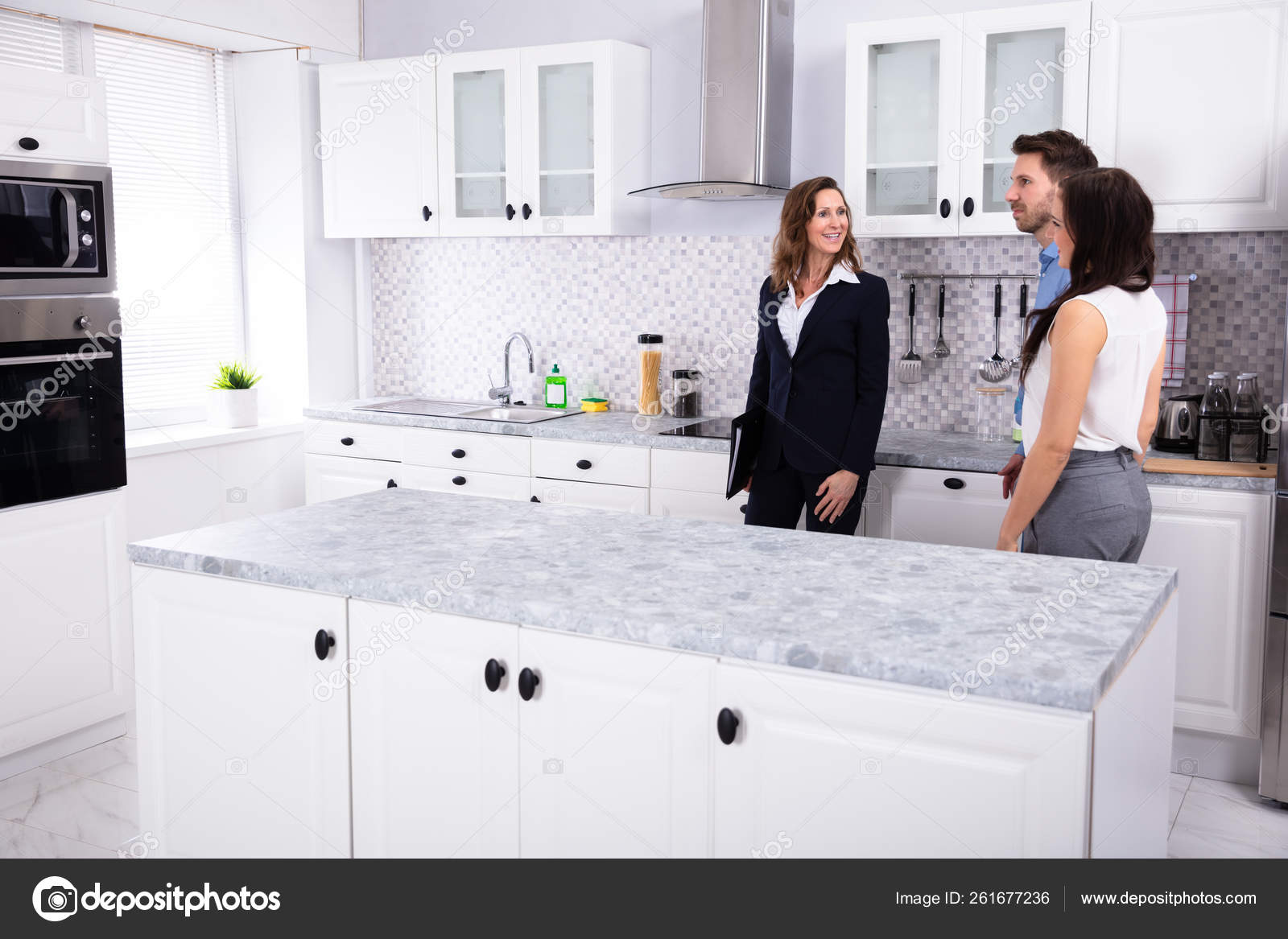 Young Woman Checking Kitchen Meeting Real Estate Agent Stock