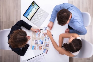 Tatil Paketi için genç bir çifte bilgi veren kadın seyahat acentesi