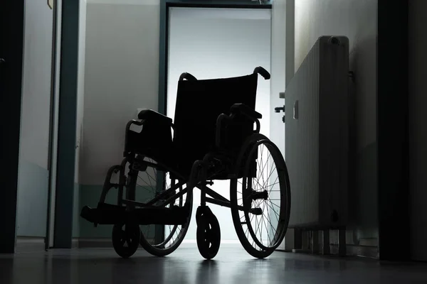 Boş Tekerlekli Sandalyenin Silüeti Hastane Koridoruna Park Edildi — Stok fotoğraf