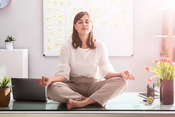 Junge Geschäftsfrau Sitzt Auf Schreibtisch Und Meditiert Büro — Stockfoto