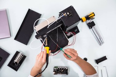 Genç kadın teknisyen aşınma Güvenlik Gözlük kullanarak lehimleme demir