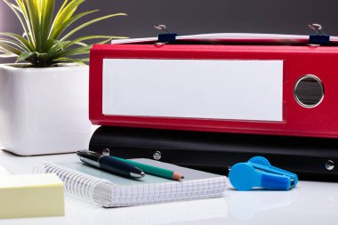Dizüstü bilgisayarı ve beyaz masadaki dizinleri olan ofis işyeri