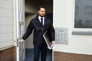 Elinde Masaüstü Taşırken Genç Teknisyen Kapıyı Açıyor