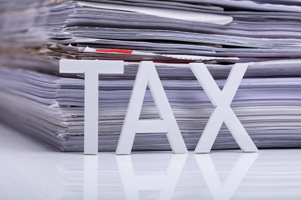 Daňový Text Před Skládanými Papírovými Soubory Reflexní Stůl — Stock fotografie