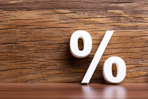 White Percentage Sign Leaning Wooden Wall — 스톡 사진