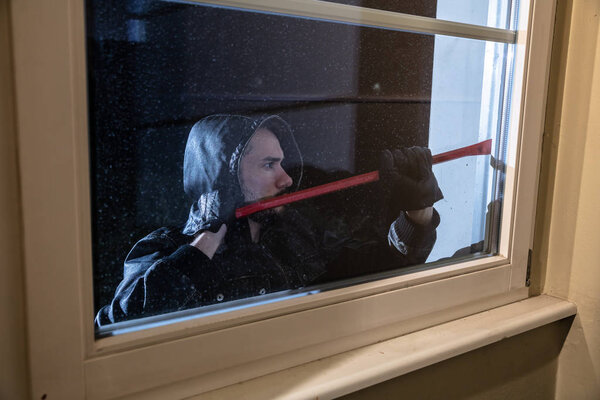 Thief Trying To Break The Window With Crowbar At Night
