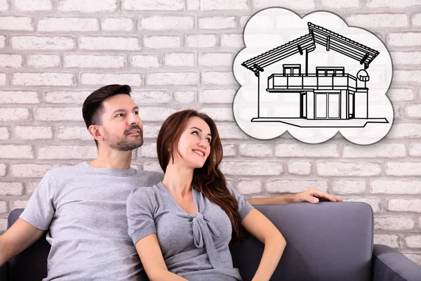 Feliz Casal Sonhando Ter Futuro Casa Enquanto Sentado Sofá — Fotografia de Stock