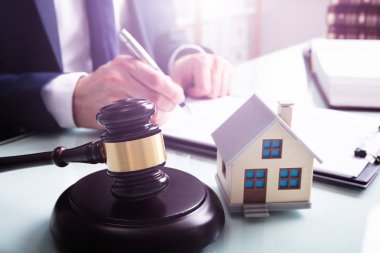 Gavel 'in ses bloğu ve ev modeli bir iş adamının önünde.