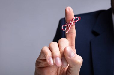 Gri Arka Plan Üzerinde Bağlı Kurdele Li Kişinin Parmağının Yakın Çekim