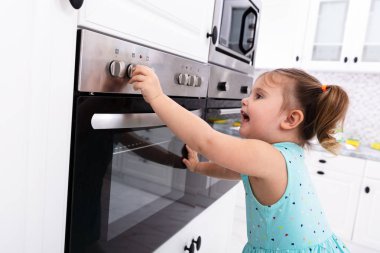 Mutfakta Elektrikli Mikrodalga Fırın ile Oynayan Küçük Kız