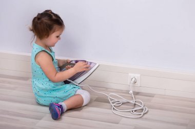 Yürüyen çocuk eve elektrik prizi takmaya çalışıyor.