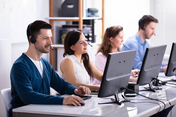 Happy Young Customer Service Executives Met Behulp Van Oortelefoons Werken — Stockfoto